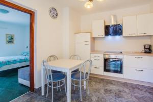 a kitchen with a table and chairs and a bed at Apartment CRES 4249-2 in Cres