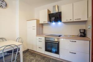 a kitchen with white cabinets and a stove top oven at Apartment CRES 4249-2 in Cres