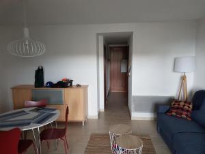 聖露西亞迪莫耶尼的住宿－Appartement T2 Bord de Mer - Maria Beach，客厅配有蓝色的沙发和桌子