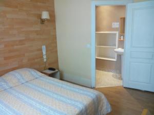 a hotel room with a bed and a bathroom at H&ocirc;tel Lamartine -Parking Dauphine in Dijon