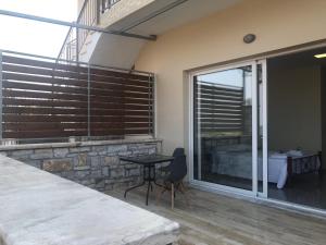 1 dormitorio con puerta de cristal, cama y mesa en Nereids Apartments-Thetis, en Petalidi
