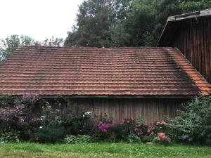 a house with a brown roof and some flowers at Ferienhof Weber Nieratz in Wangen im Allgäu +26 photos