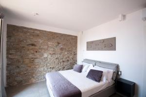 a bedroom with a bed and a stone wall at Cinque Terre Coast to Coast in Riomaggiore