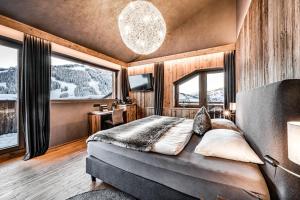 sypialnia z łóżkiem w pokoju z oknami w obiekcie ALMMONTE SENSUM SUITES Boutique Hotel w mieście Wagrain +37 zdjęć
