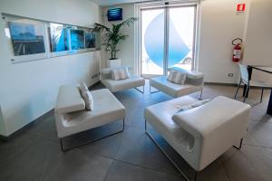 a living room with white furniture and a fishtank at Smy Aran Blu Roma Mare in Lido di Ostia