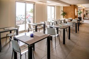 a dining room with tables and chairs in a restaurant at Smy Aran Blu Roma Mare in Lido di Ostia