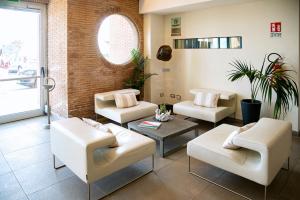 a living room with white chairs and a table at Smy Aran Blu Roma Mare in Lido di Ostia
