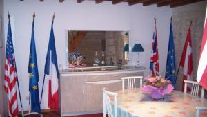 uma cozinha com uma mesa e bandeiras num quarto em Maison de la Libération 6 Juin 1944 OMAHA BEACH em Saint-Laurent-sur-Mer