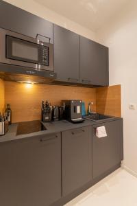 eine Küche mit einer Spüle und einer Mikrowelle in der Unterkunft Albrecht I levestate in Wien