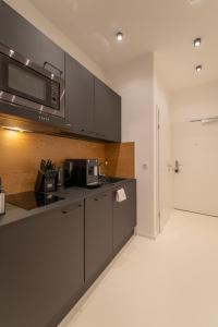 a kitchen with gray cabinets and a microwave at Albrecht I levestate in Vienna