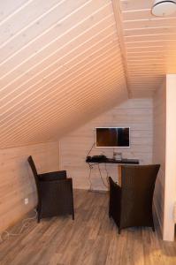 um quarto com duas cadeiras e uma mesa com televisão em Vanamo em Ylläsjärvi