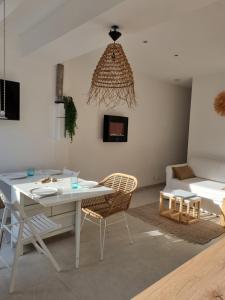 een woonkamer met een witte tafel en stoelen bij Superbe appartement au coeur du Cap-Ferret in Cap-Ferret