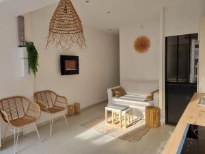 ein Wohnzimmer mit 2 Stühlen und einem Sofa in der Unterkunft Superbe appartement au coeur du Cap-Ferret in Cap-Ferret
