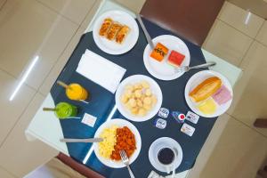 una mesa azul con platos de comida. en Ano Bom Palace Hotel, en Barra Mansa