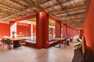 uma sala de jantar com mesas e cadeiras e uma piscina em LUZ Culinary Wine Lodge em José Ignacio