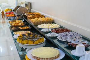 a buffet filled with different types of pastries and desserts at Ano Bom Palace Hotel in Barra Mansa