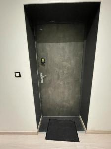 una puerta con una alfombra negra delante de ella en Sympathique petit Studio à la frontière du Luxembourg, en Knutange