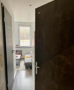 Una puerta que conduce a una habitación con dormitorio en Sympathique petit Studio à la frontière du Luxembourg, en Knutange