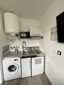 eine Küche mit einer Spüle und einer Waschmaschine in der Unterkunft Sympathique petit Studio à la frontière du Luxembourg in Knutange