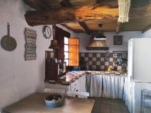 a kitchen with a table and a clock on the wall at La Casita de Betania in Benaocaz