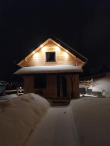 a small house covered in snow at night at Słoneczny Domek in Kluszkowce