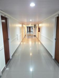 um corredor vazio num edifício com pisos e tectos brancos em Ano Bom Palace Hotel em Barra Mansa