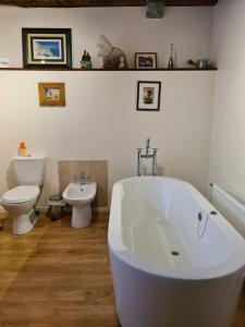 un bagno con vasca, WC e lavandino di Gîte d'étape Le Couvent d'Ossau a Louvie Juzon