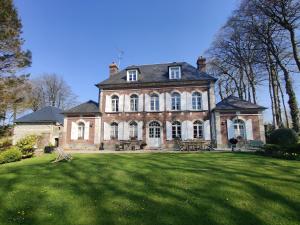 a large brick house with a large grass yard at Le Clos des Hautes Loges in Les Loges