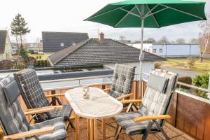 a table and chairs with an umbrella on a balcony at Maisonette-Ferienwohnung Karla in Ostseebad Karlshagen +19 photos
