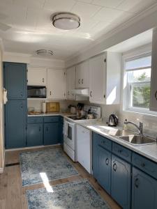 a kitchen with blue and white cabinets and a sink at Rocky Harbour Oceanfront in Rocky Harbour