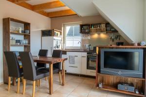 a kitchen with a dining room table and a tv at Maisonette-Ferienwohnung Karla in Ostseebad Karlshagen