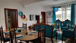 a dining room with a table and blue chairs at The Octagon - Family Apparts - Wing B - A cozy place to stay, start and end your holidays in Mahébourg