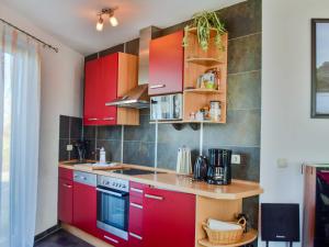 a kitchen with red cabinets and a counter at Ferienhaus Bodden in Neuendorf