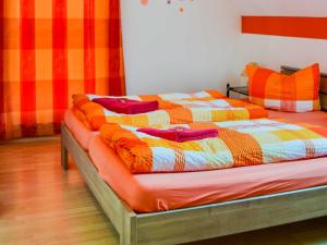 a bed with a colorful blanket on top of it at Ferienhaus Bodden in Neuendorf