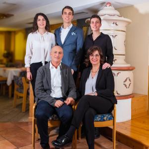 a group of people posing for a picture in front of a cake at Albergo Dimaro Wellness Hotel in Dimaro