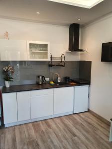a kitchen with white cabinets and a black counter top at Serce Krynicy in Krynica Morska