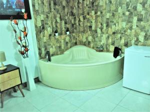 a bath tub in a bathroom with a stone wall at Hotel Septima Maravilla Lunahuana in Lunahuaná