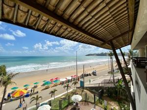 a view of a beach with umbrellas and the ocean at Elegance Comfort Natal Beira Mar in Natal