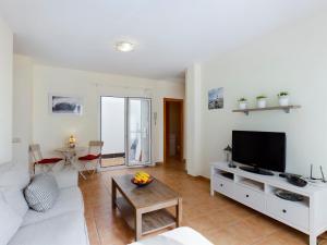 a living room with a white couch and a tv at Oliastur1 Sunset Beach El Cotillo in El Cotillo