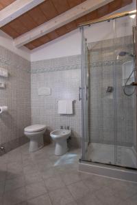 a bathroom with a toilet and a glass shower at Hotel Valle Verde in Procchio