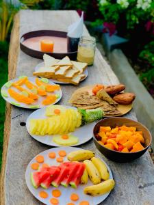 a table with plates of different types of fruits and vegetables at Uroa Getaway in Uroa