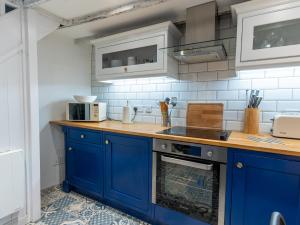 una cucina con armadi blu e piano di lavoro di Finest Retreats - Old Harbour Cottage a Mevagissey