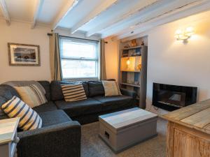 a living room with a couch and a tv at Finest Retreats - Old Harbour Cottage in Mevagissey