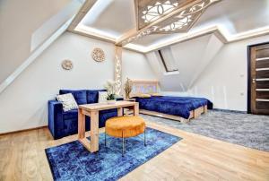 a living room with a blue couch and a table at Willa Pod Grapą in Poronin