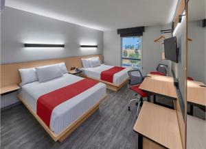 Habitación con 2 camas, escritorio y TV. en Hotel Best Place Express en Zamora de Hidalgo