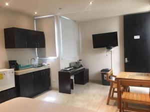 a kitchen with black cabinets and a table and a sink at 770 Apartments in Playa del Carmen
