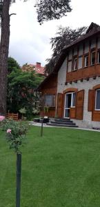 een huis met een groene tuin met een boom bij Serce Krynicy in Krynica Morska