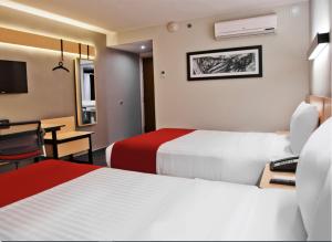 Habitación de hotel con 2 camas y escritorio en Hotel Best Place Express en Zamora de Hidalgo