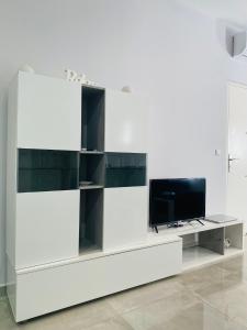 a white entertainment center with a flat screen tv at Luxury Suite Fuengirola 1 in Fuengirola