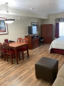 una camera d'albergo con tavolo, sedie e letto di Homestead Lodge Apart Hotel a Pleasantville